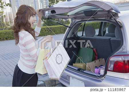 車のトランクを開けて驚く女性の写真素材