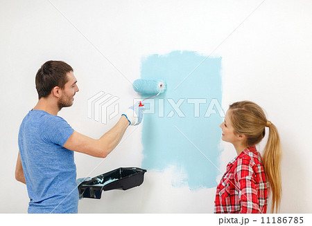smiling couple painting wall at home 11186785