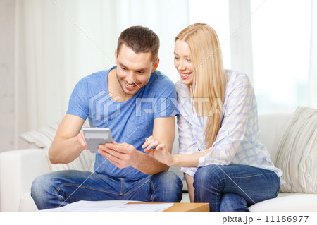 smiling couple with papers and calculator at home 11186977