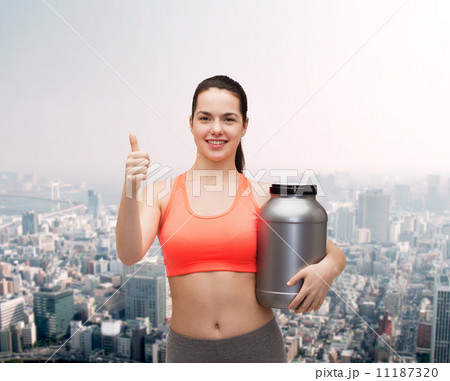 teenage girl with jar of protein showing thumbs up teenage girl with jar of protein showing thumbs up 11187320