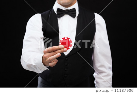 dealer holding red poker chip 11187906