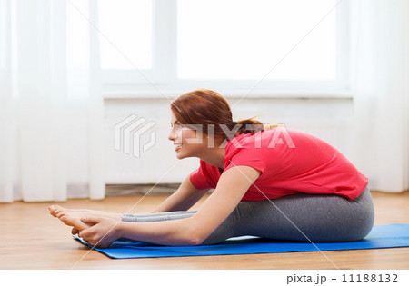 smiling teenage girl streching on floor at home 11188132
