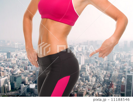 close up of sporty woman pointing at her buttocks 11188546