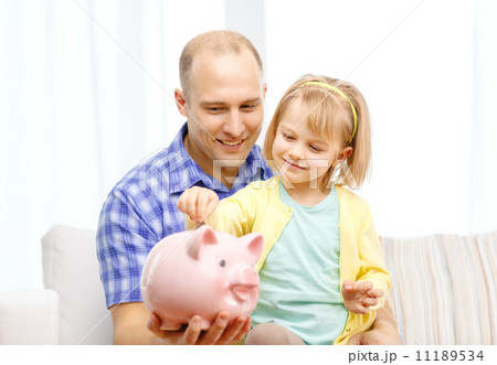 happy father and daughter with big piggy bank happy father and daughter with big piggy bank 11189534