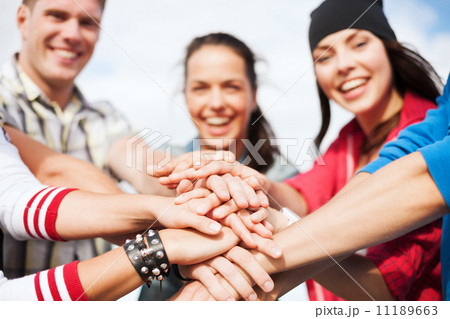 teenagers hands on top of each other outdoors 11189663