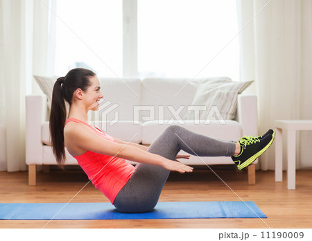 smiling girl doing exercise on floor at home smiling girl doing exercise on floor at home 11190009