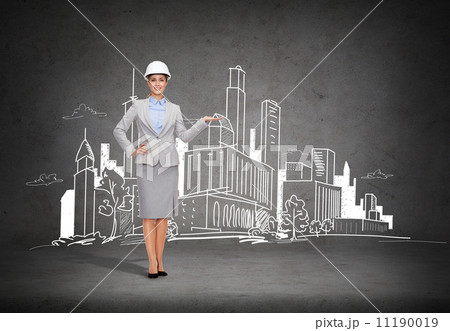 businesswoman in helmet showing town drawing 11190019