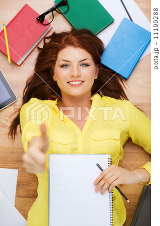 smiling female student with textbook and pencil 11190288