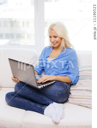 smiling woman with laptop computer at home smiling woman with laptop computer at home 11190523