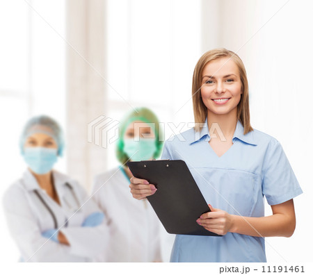 smiling female doctor or nurse with clipboard smiling female doctor or nurse with clipboard 11191461