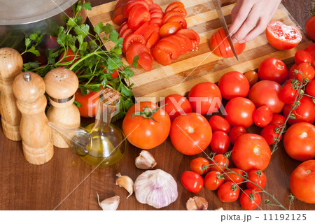 Closeup of hands slicing tomatoes 11192125