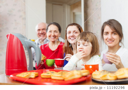 family posing over tea at home 11192296
