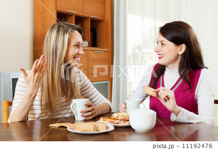 Two young women drinking tea with cookies Two young women drinking tea with cookies 11192476