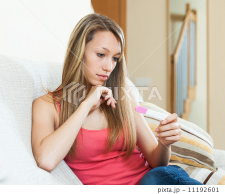 Sad girl with pregnancy test 11192601