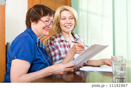 elderly woman working with contracts elderly woman working with contracts 11192867