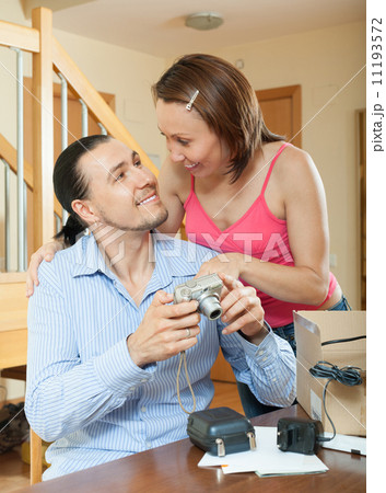 couple unpacking new compact digital camera couple unpacking new compact digital camera 11193572