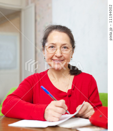 mature woman counts family budget 11194002