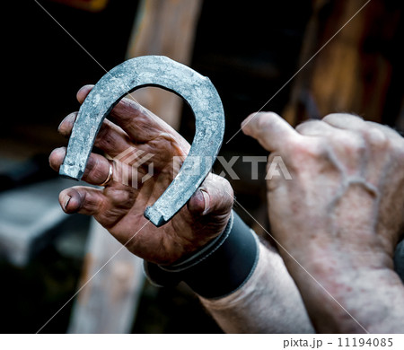 Blacksmith's dirty hands holding horseshoe Blacksmith's dirty hands holding horseshoe 11194085
