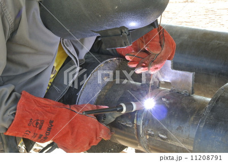 A welder welding a pipe 11208791