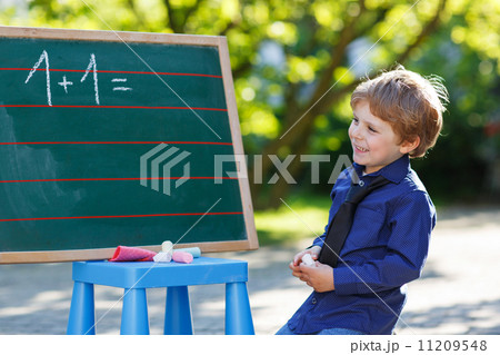 Little boy at blackboard practicing mathematics Little boy at blackboard practicing mathematics 11209548