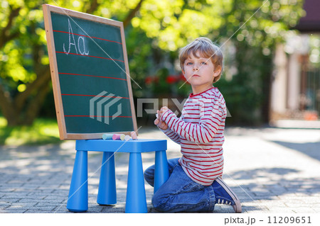 Little boy at blackboard practicing mathematics Little boy at blackboard practicing mathematics 11209651
