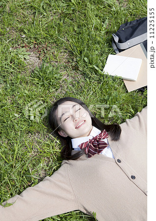 芝生に寝転ぶ女子高生 11225155