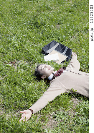 芝生に寝転ぶ女子高生 11225203