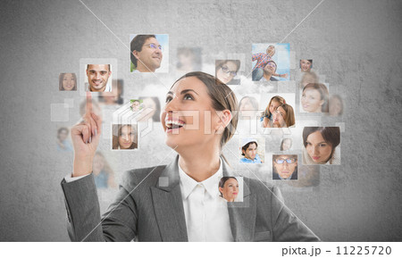 Young successful business woman looking at people portraits. Int 11225720