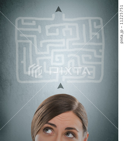 Young businesswoman looking at the labyrinth and thinking about Young businesswoman looking at the labyrinth and thinking about 11225751
