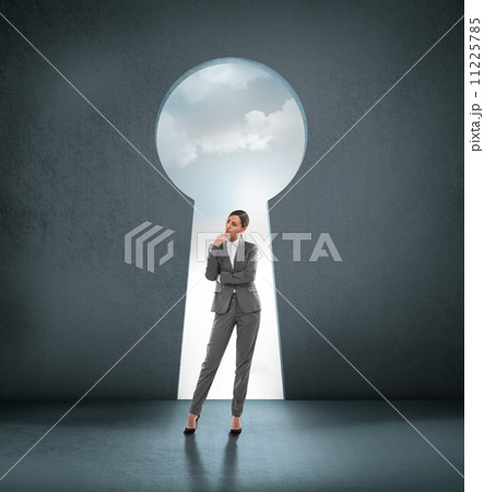 Businesswoman standing in front of opened concrete wall 11225785