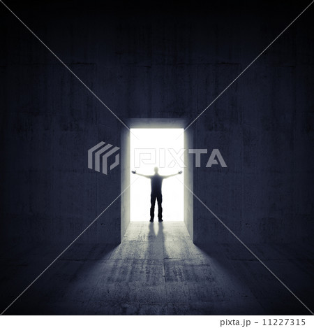Abstract dark concrete interior with glowing door and man silhou Abstract dark concrete interior with glowing door and man silhou 11227315