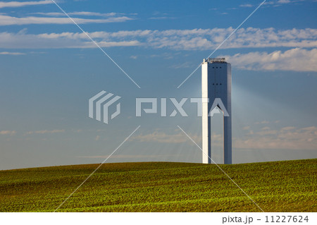 Solar Tower with rays  - thermo-solar power - blue sky and green 11227624