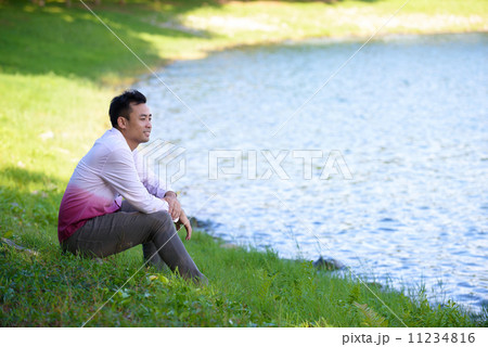 Young man in causal alone in thoughts near the edge of the waters 11234816