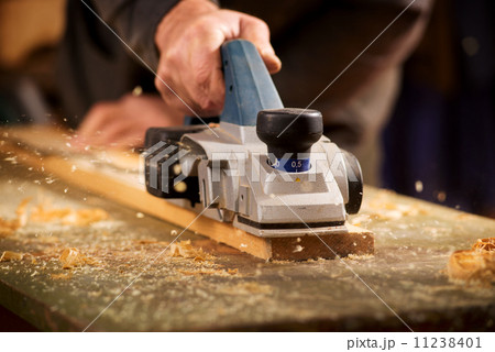 Elderly man planing a plank of wood Elderly man planing a plank of wood 11238401