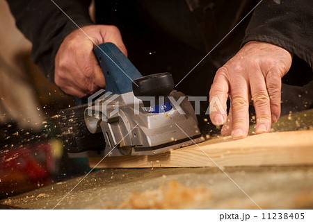 Elderly man planing a plank of wood Elderly man planing a plank of wood 11238405
