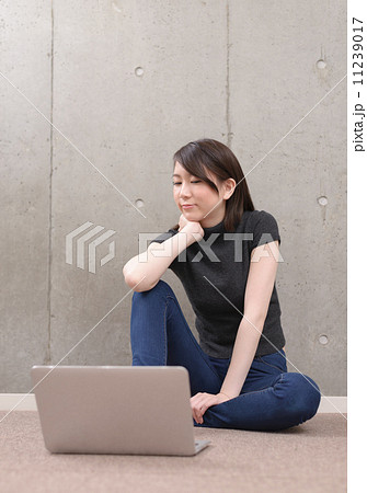 床に座ってラップトップを使う若い女性 床に座ってラップトップを使う若い女性 11239017