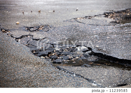Broken pavement and pothole asphalt road after winter. 11239585