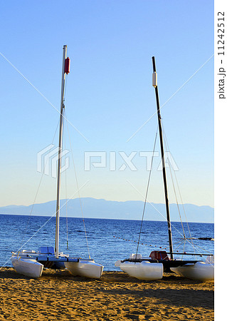 Sailboat Stands on the Beach Against the Blue Sea Sailboat Stands on the Beach Against the Blue Sea 11242512