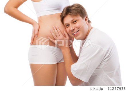 Husband listening to his wife's belly Husband listening to his wife's belly 11257933