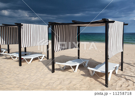 Different parasols and sun loungers on the empty beach on Tavira 11258718
