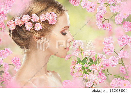 Beauty face of young beautiful woman with pink flowers in her hair 11263804