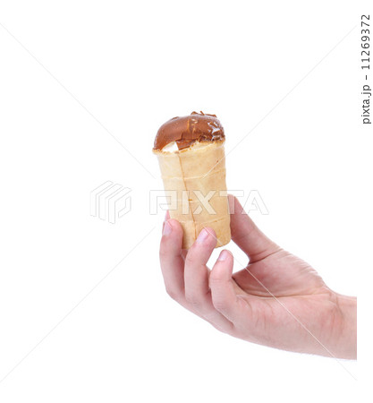 Hand holds waffle cup of chocolate ice cream. 11269372