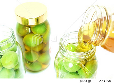 季節の味覚梅ジュース・抽出させる蜂蜜を注ぐ工程・瓶詰め数本白バックやや俯瞰アップ横位置 11273150