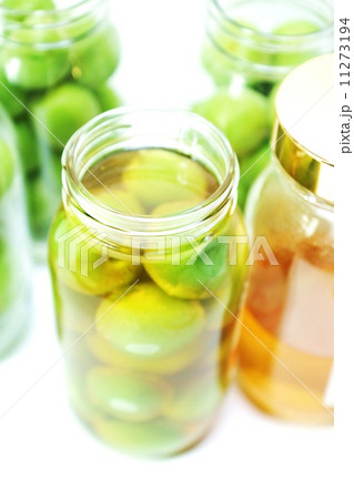 季節の味覚梅ジュース・蜂蜜を注ぎ終わった１瓶の口アップ・瓶詰め数本白バック縦位置 11273194