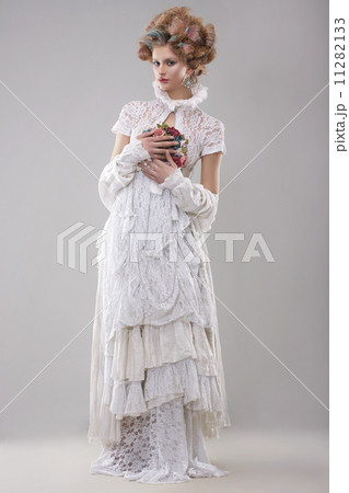 Elegance. Gorgeous Fashion Model in Long Gown and Bouquet of Flowers 11282133