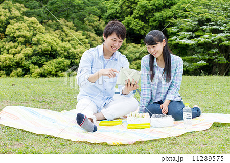 公園 カップル お弁当の写真素材