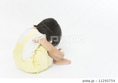 膝を抱える子供の写真素材