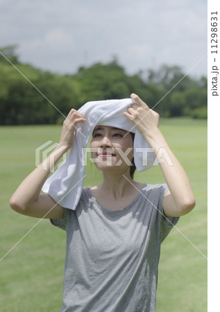 Asian woman wiping sweat with a towel after exercising Asian woman wiping sweat with a towel after exercising 11298631
