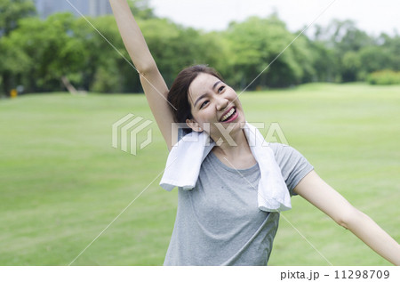 sporty girl warming up stretch her legs in the park 11298709