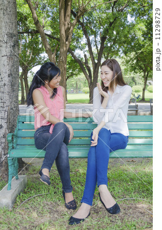 Two young beautiful Asian women talking about something at summe Two young beautiful Asian women talking about something at summe 11298729